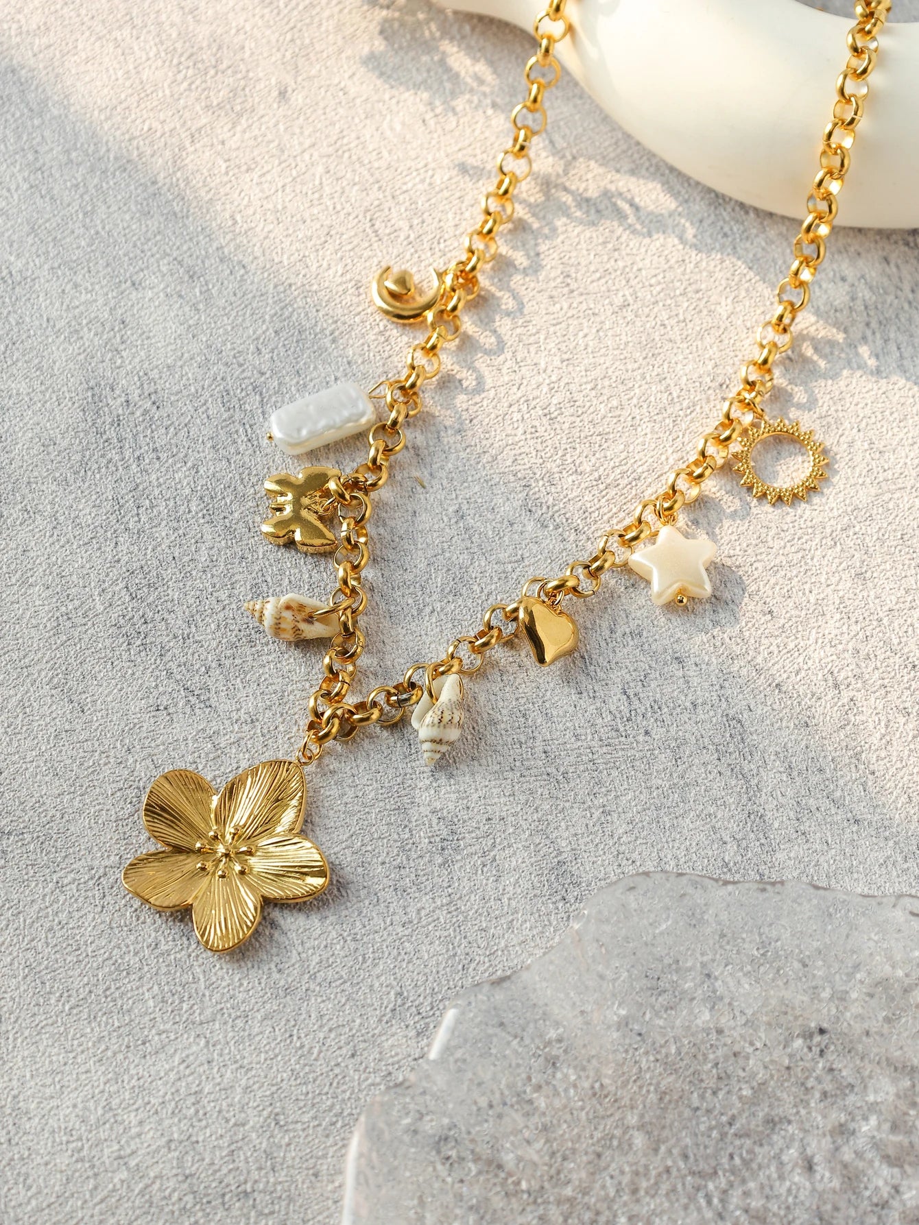 Close-up of 18K gold star ,shell and moon pendant on ORL'A Jewelry Store necklace