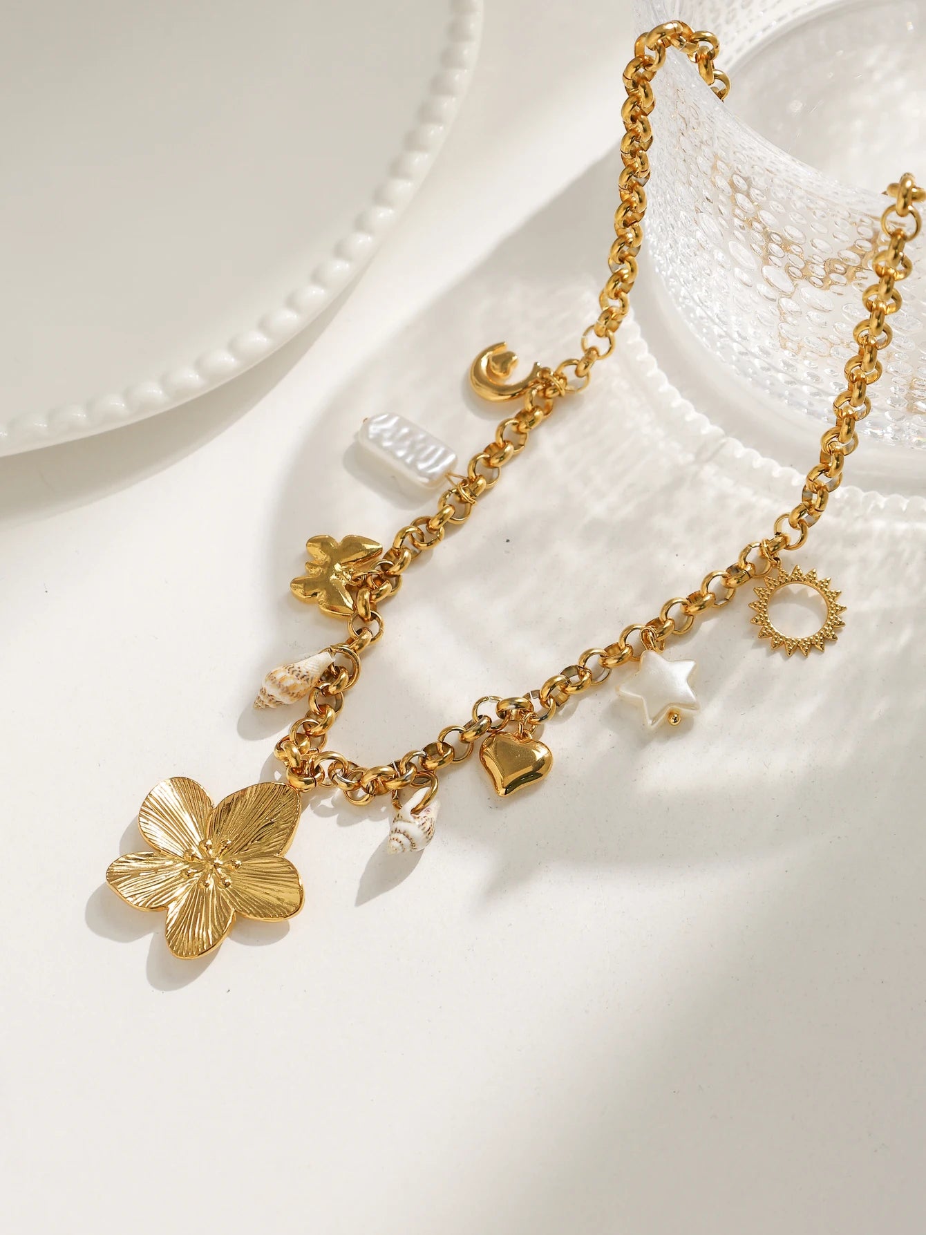 Close-up of 18K gold star, moon and shell charms hypoallergenic necklace by ORL'A Jewelry Store
