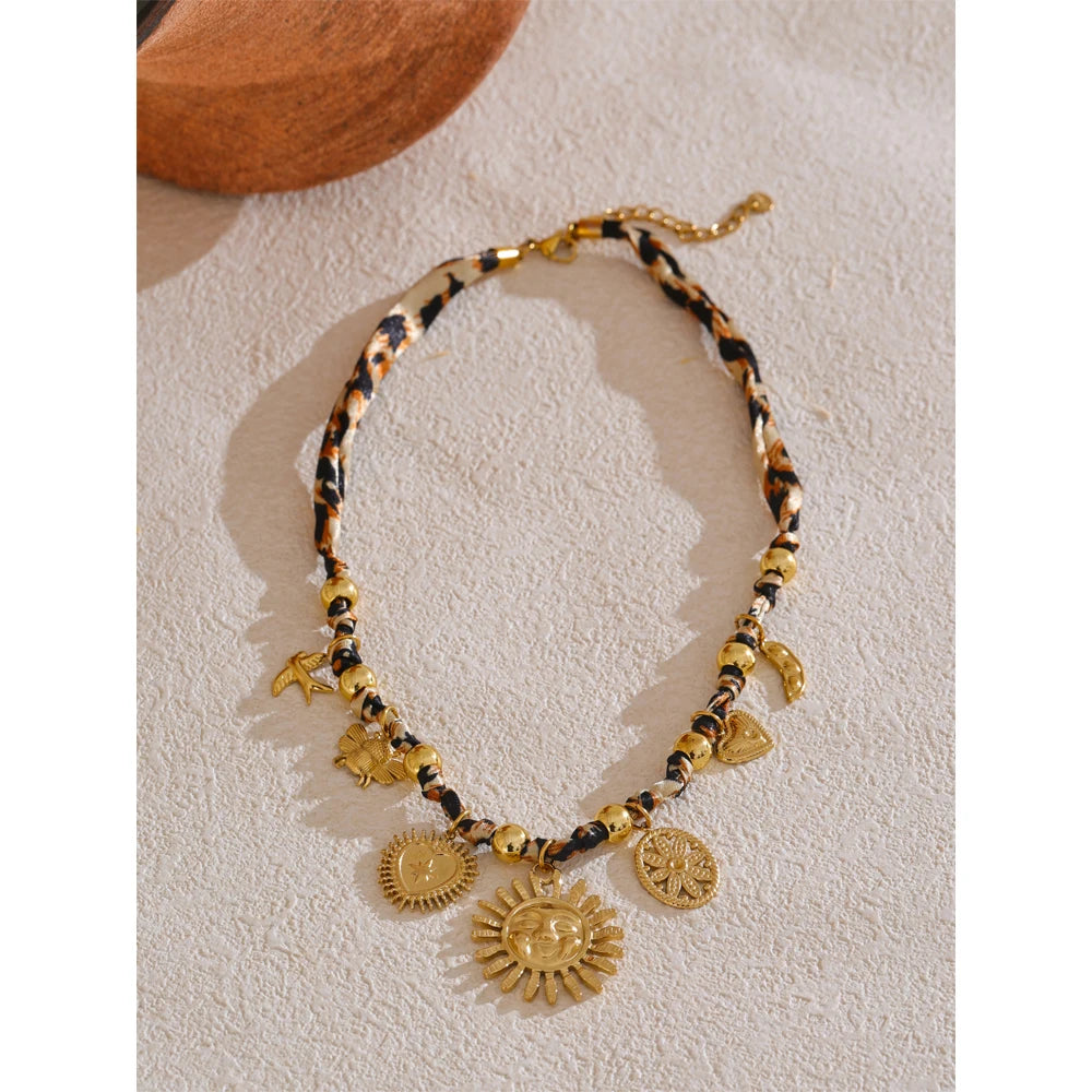 Close-up of 18K gold leopard sunflower pendant detail on plain background by ORLA