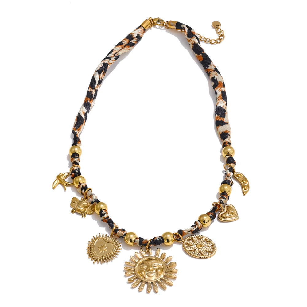 Close-up of 18K gold leopard sunflower pendant detail on white background