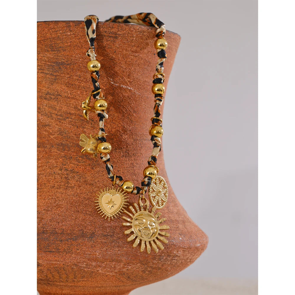 Extreme close-up of 18K gold leopard print sunflower pendant with textured details on wooden piece