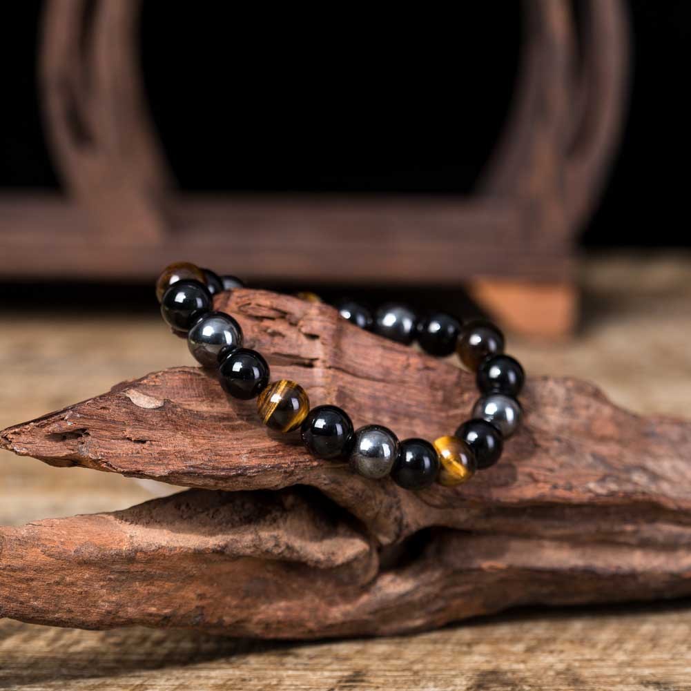 Close-up of The Grounded One bracelet by ORL'A Jewelry Store on natural wood, emphasizing earthy grounding, protection, and strength