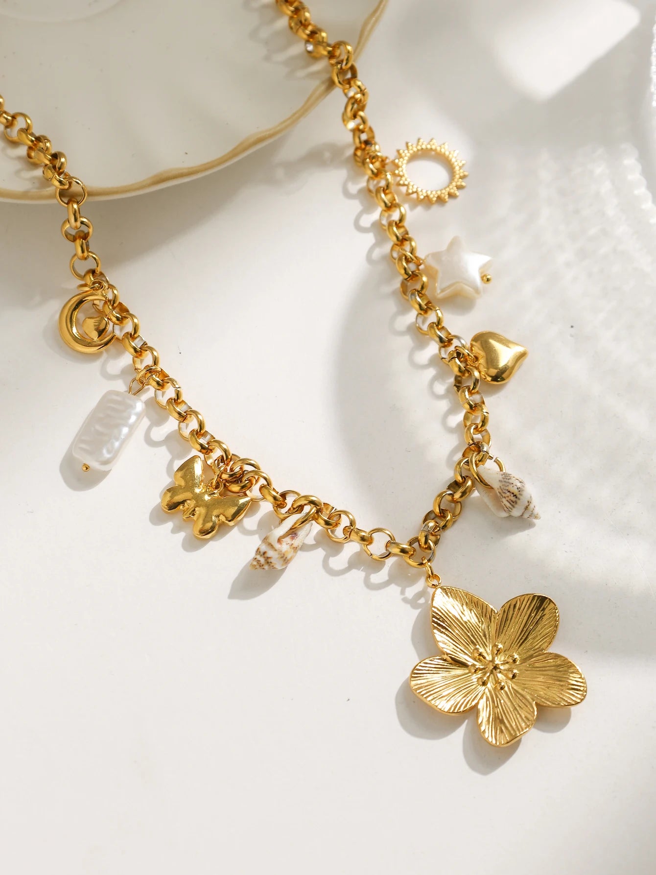 Waterproof ORL'A Jewelry Store gold necklace flatlay on whiye background with shadow. 