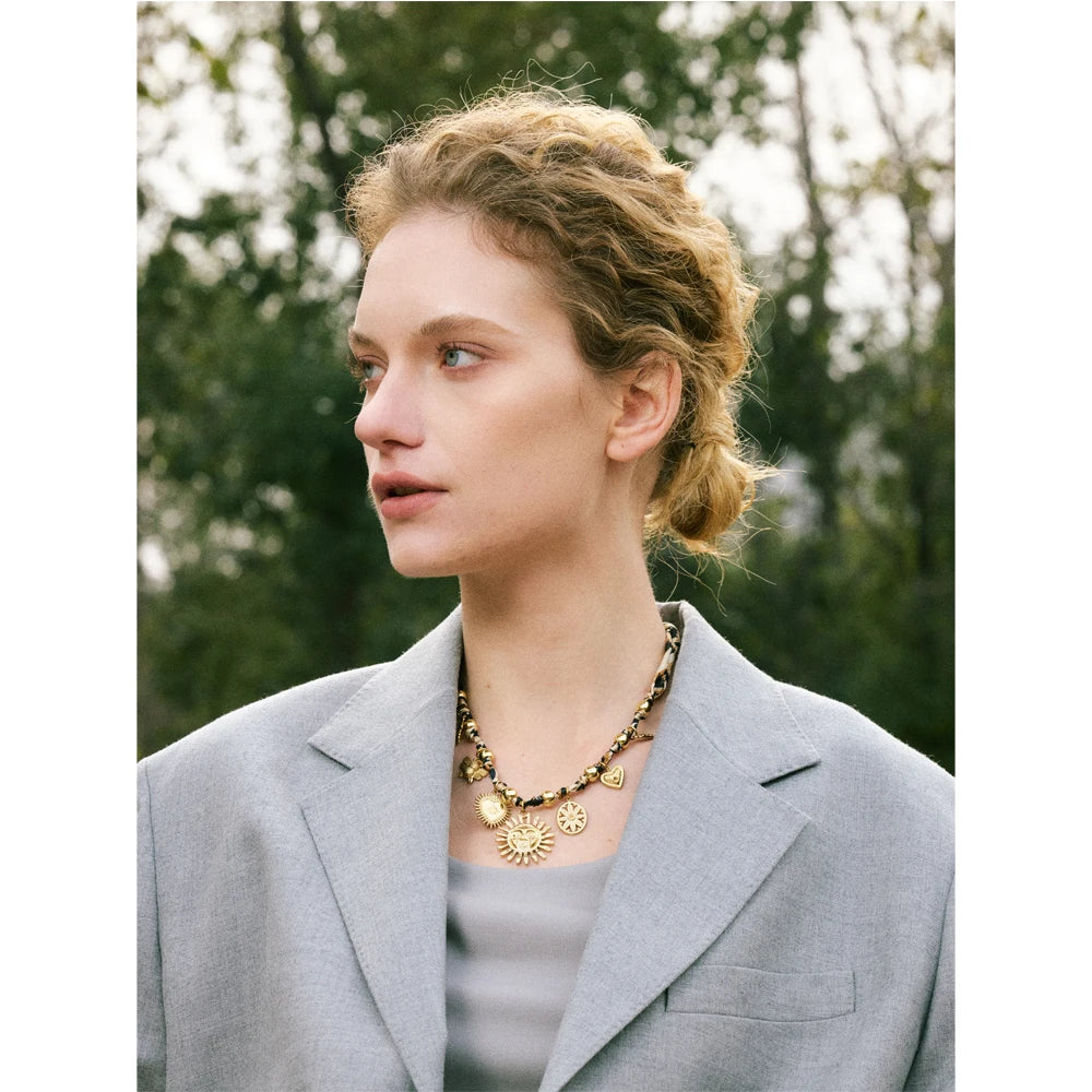 Stylish woman wearing ORLA leopard sunflower necklace with grey dress